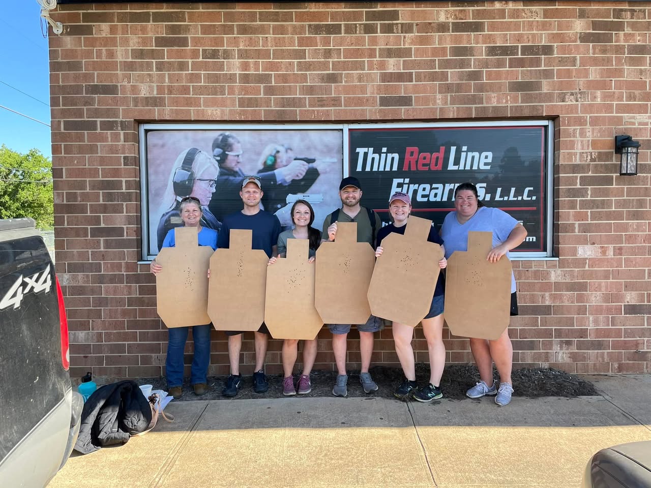 Katie Tallent and classmates with their targets outside Thin Red Line Firearms